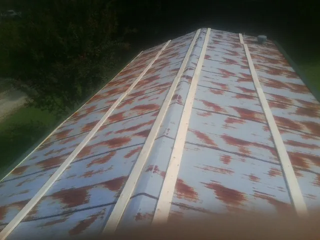 Rusted metal roof panels with new wood purlins before replacement — Storm Damage Roof Repair in China Grove by Roofing Brothers