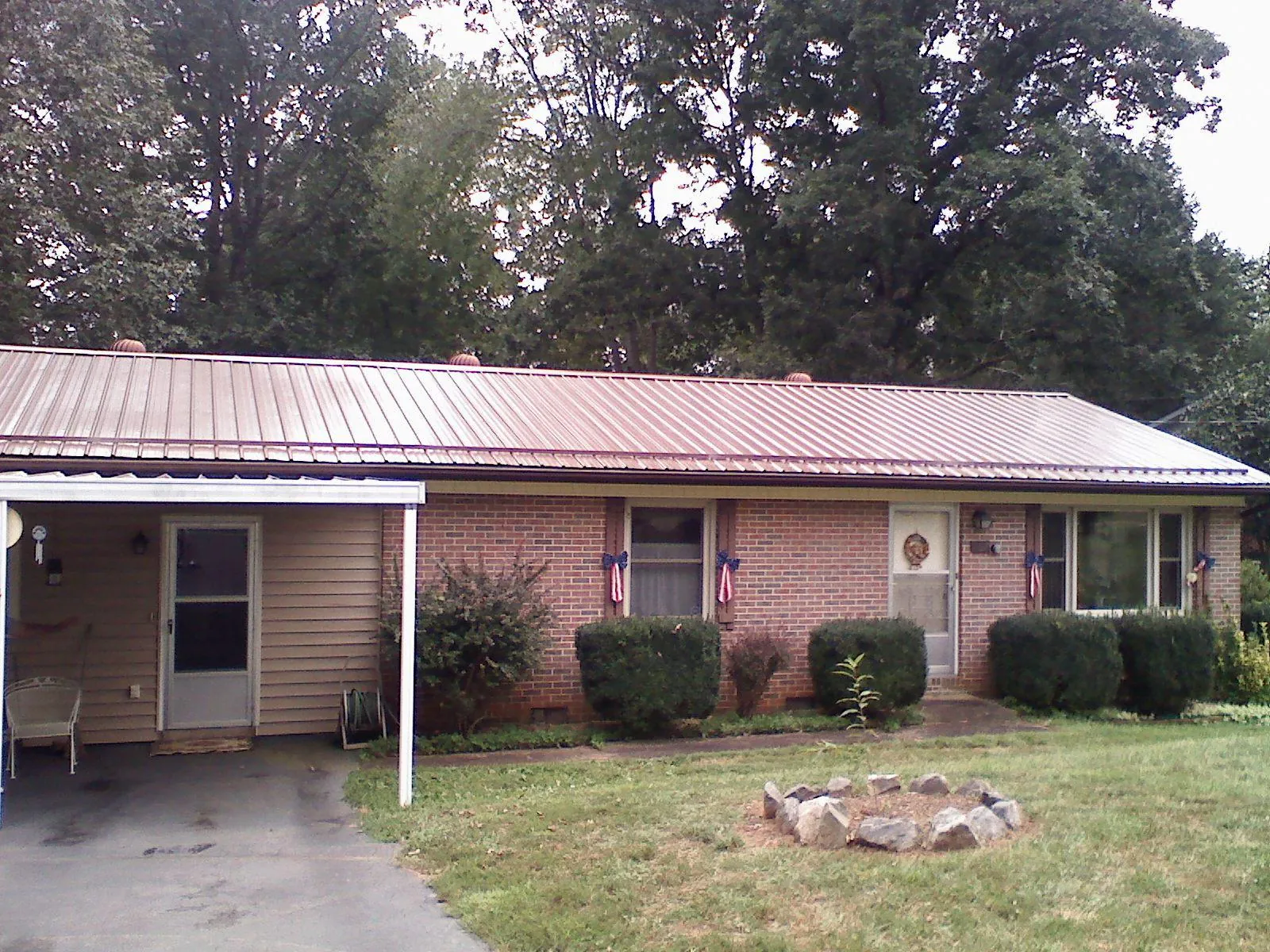 Bronze metal roof and carport on a brick ranch home — Roof Repair work by our crew in China Grove